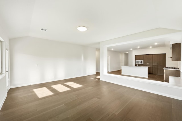 unfurnished living room featuring wood-type flooring and lofted ceiling