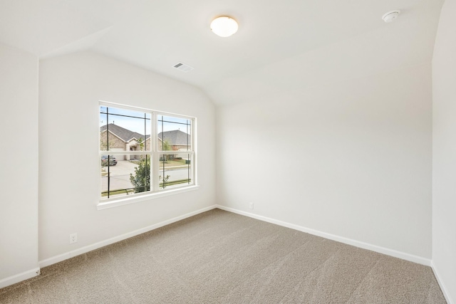 carpeted empty room featuring lofted ceiling