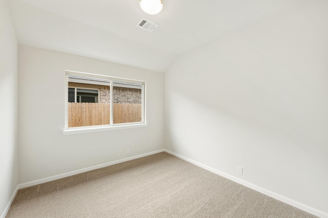 spare room with carpet floors and lofted ceiling