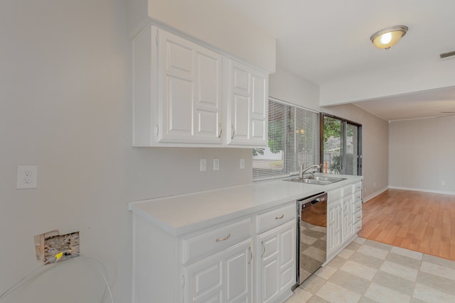 kitchen with light hardwood / wood-style floors, dishwasher, sink, and white cabinets