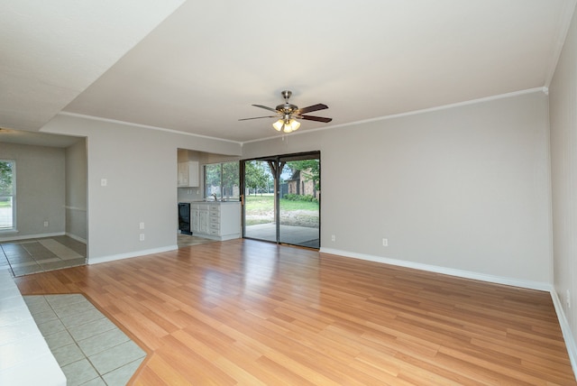 unfurnished living room with ceiling fan, sink, light wood-type flooring, and ornamental molding