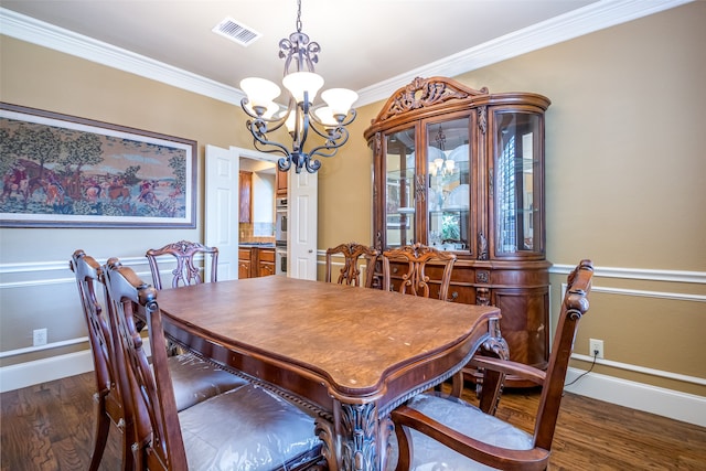 dining room with ornamental molding, a chandelier, and dark hardwood / wood-style floors