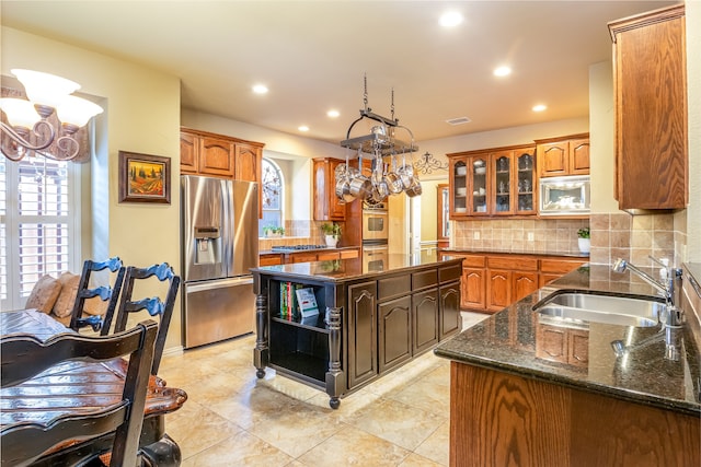 kitchen with appliances with stainless steel finishes, a center island, and an inviting chandelier