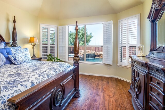 bedroom with vaulted ceiling and dark wood-type flooring