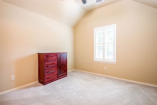 unfurnished bedroom featuring light carpet, vaulted ceiling, and ceiling fan