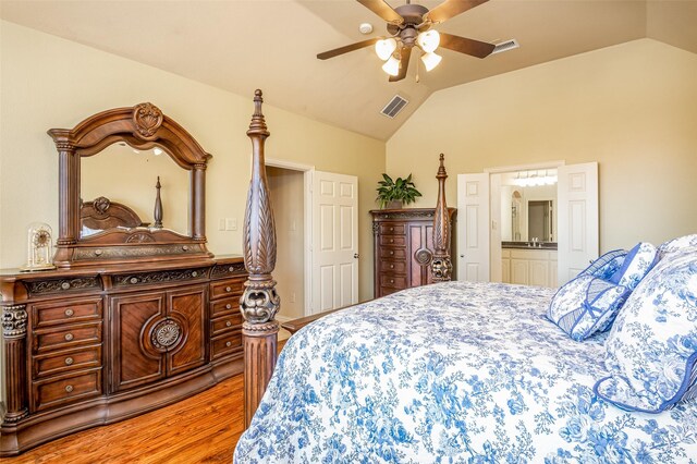 bedroom featuring wood-type flooring, connected bathroom, vaulted ceiling, and ceiling fan