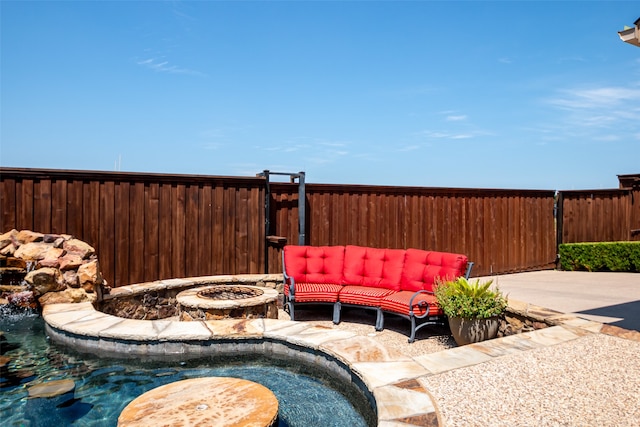 view of pool with a patio and an outdoor living space with a fire pit