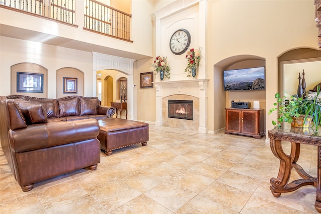 living room featuring a tile fireplace and a high ceiling