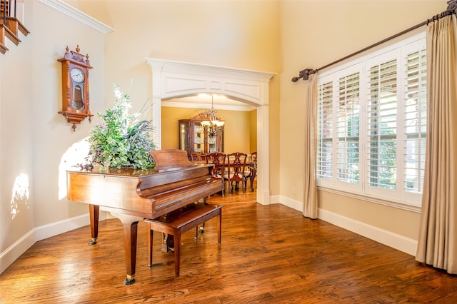 misc room with hardwood / wood-style flooring, crown molding, and a chandelier