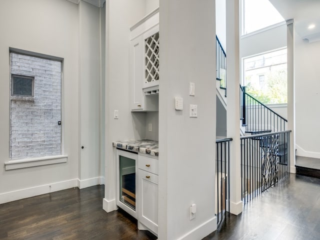 kitchen with white cabinets, light stone countertops, and dark hardwood / wood-style floors