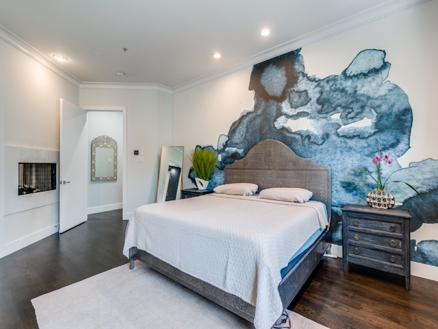 bedroom with a fireplace, crown molding, and dark wood-type flooring