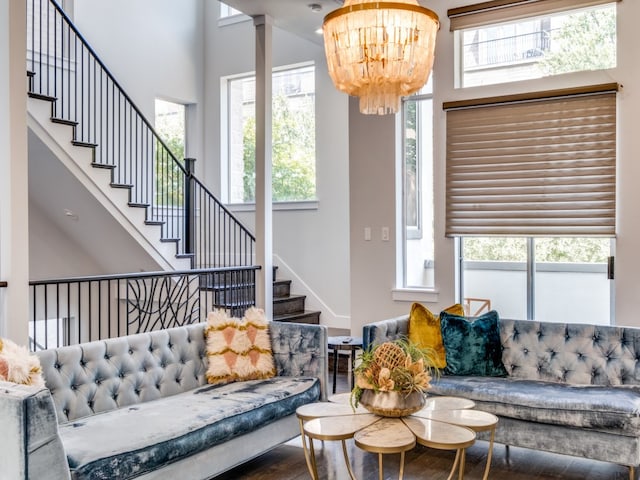 living room with a towering ceiling, a chandelier, hardwood / wood-style floors, and a wealth of natural light