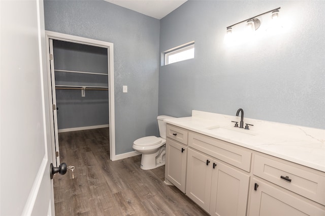 bathroom featuring wood-type flooring, vanity, and toilet