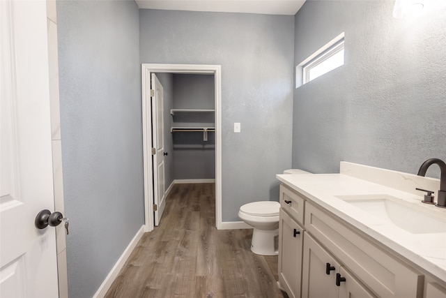 bathroom with wood-type flooring, vanity, and toilet