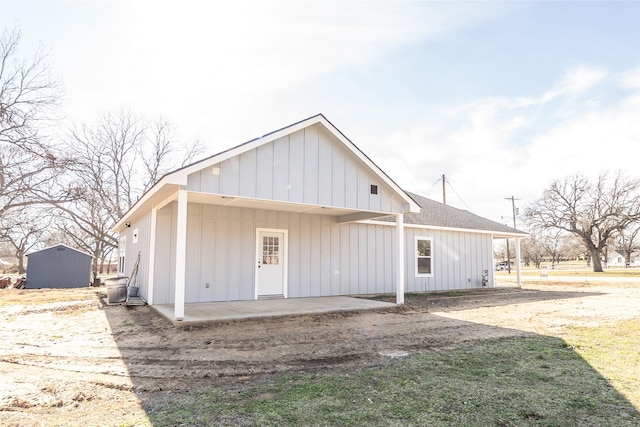 back of property featuring a storage unit and a patio area