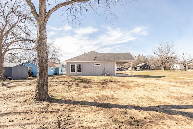 back of house featuring a storage shed and a carport