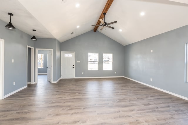 spare room with light hardwood / wood-style flooring, ceiling fan, beamed ceiling, and a wealth of natural light