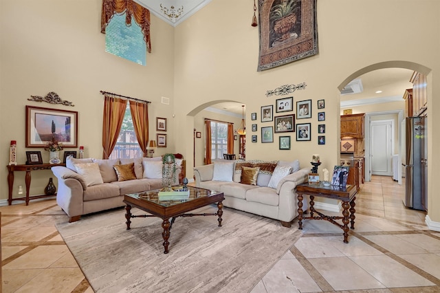 living room featuring a towering ceiling, light tile patterned flooring, and crown molding