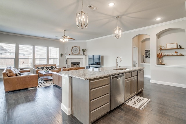 kitchen featuring hanging light fixtures, dark wood-type flooring, an island with sink, ceiling fan with notable chandelier, and sink