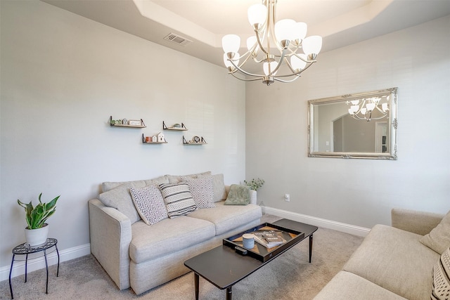 carpeted living room featuring an inviting chandelier and a raised ceiling