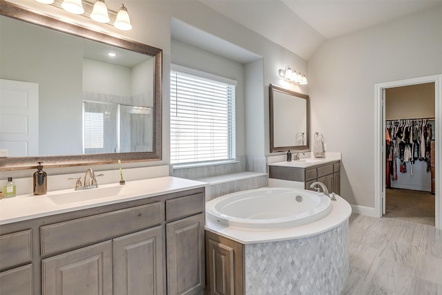 bathroom featuring vanity, vaulted ceiling, and plus walk in shower