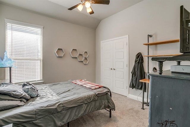 bedroom featuring lofted ceiling, multiple windows, light colored carpet, and ceiling fan