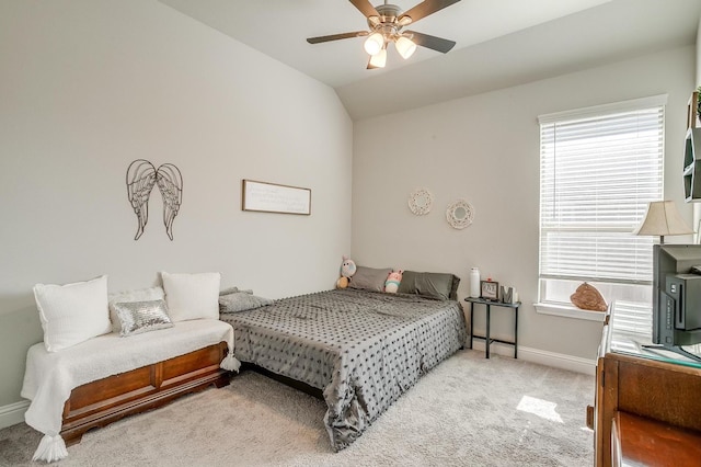 bedroom with ceiling fan, light colored carpet, vaulted ceiling, and multiple windows