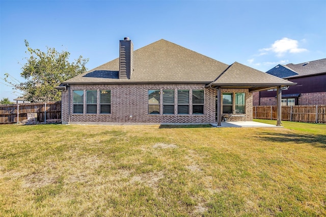 back of property featuring a lawn and a patio