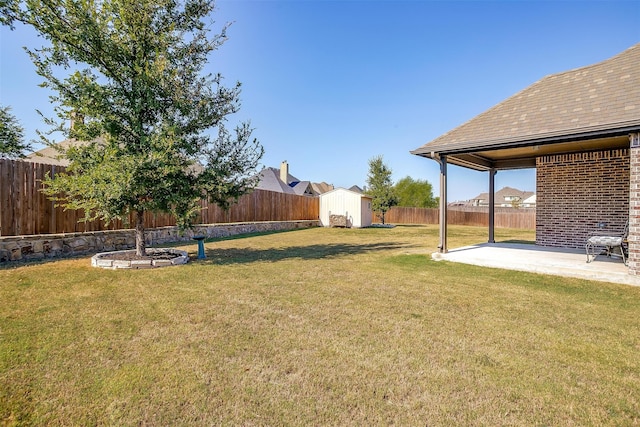 view of yard with a storage shed and a patio