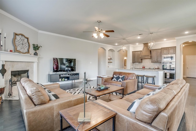 living room with crown molding, hardwood / wood-style floors, and ceiling fan