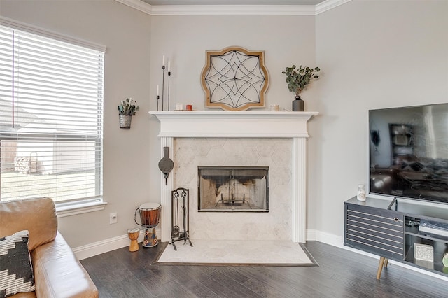 living room featuring a tile fireplace, crown molding, wood-type flooring, and plenty of natural light