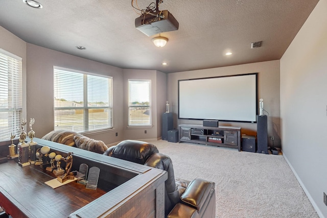 carpeted home theater featuring a textured ceiling