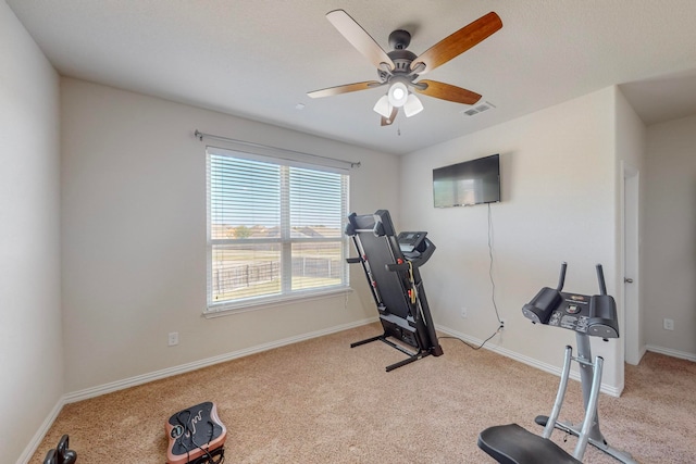 workout room featuring light carpet and ceiling fan