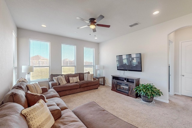 carpeted living room with ceiling fan