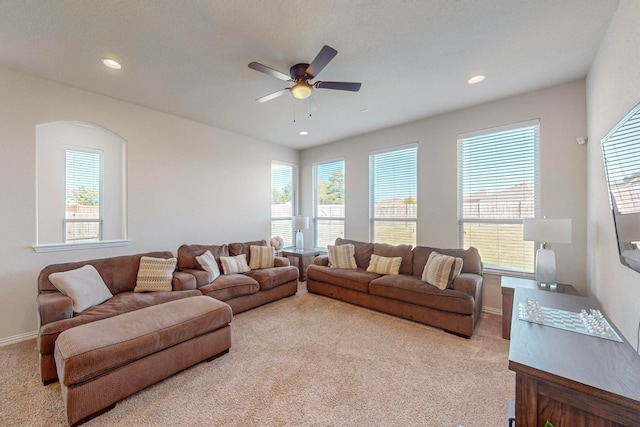 carpeted living room featuring a wealth of natural light and ceiling fan