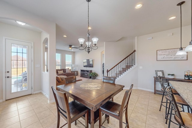 dining space with light tile patterned flooring and ceiling fan with notable chandelier