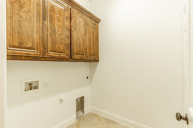 laundry room with hookup for a gas dryer, hookup for a washing machine, hookup for an electric dryer, light tile patterned flooring, and cabinets