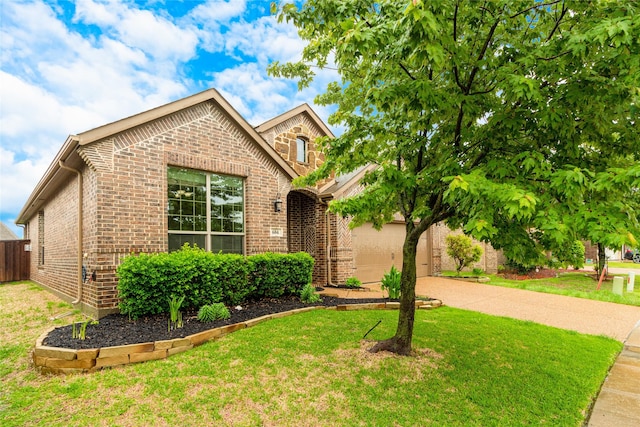 view of front of house with driveway, brick siding, a front yard, and fence