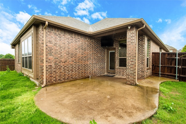 back of house featuring a lawn and a patio area