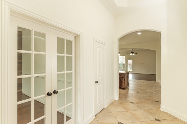 hall with crown molding and light tile patterned floors