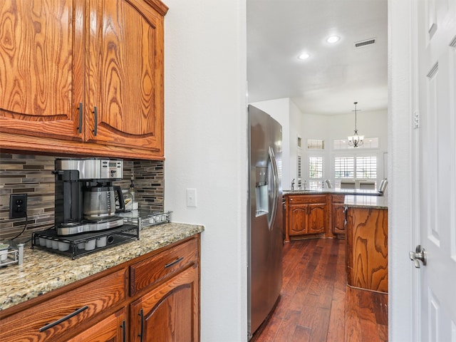 kitchen featuring an inviting chandelier, stainless steel fridge, dark hardwood / wood-style floors, and tasteful backsplash