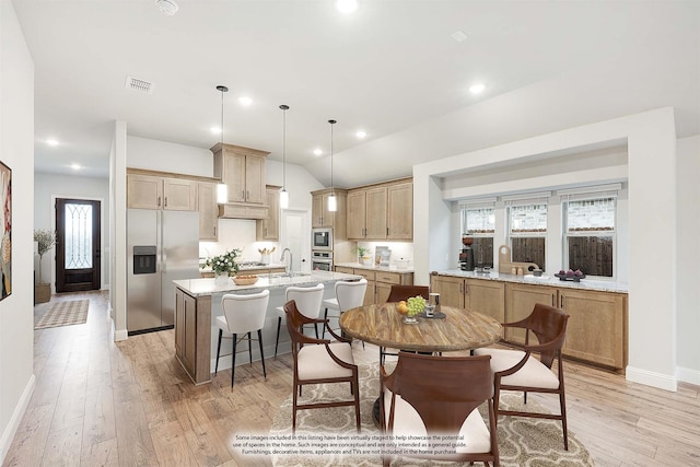 dining space with plenty of natural light, light wood-type flooring, sink, and lofted ceiling