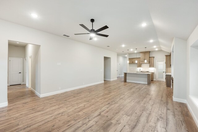 unfurnished living room with light hardwood / wood-style floors, ceiling fan, and lofted ceiling