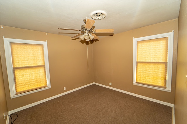 empty room featuring dark colored carpet and ceiling fan