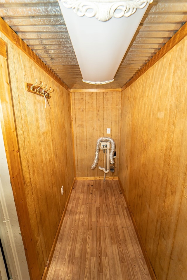 hall with wood walls and hardwood / wood-style floors