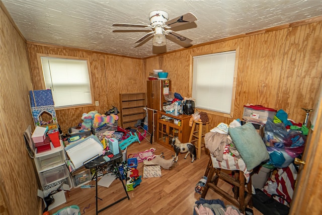 miscellaneous room featuring ceiling fan, hardwood / wood-style flooring, and wooden walls