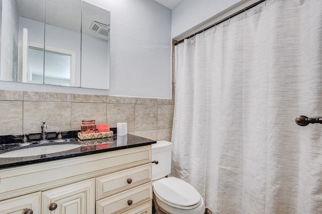 bathroom featuring tile walls, vanity, and toilet