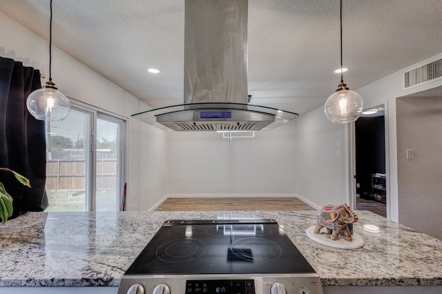 kitchen featuring black range, light stone counters, island range hood, and hanging light fixtures