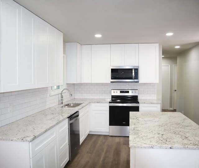 kitchen with sink, white cabinetry, backsplash, appliances with stainless steel finishes, and dark hardwood / wood-style flooring