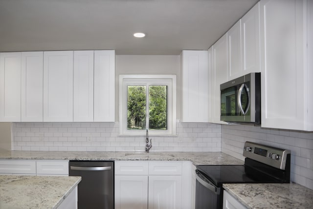 kitchen featuring appliances with stainless steel finishes, backsplash, and white cabinets